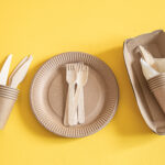 eco friendly disposable dishes made paper on an orange background.